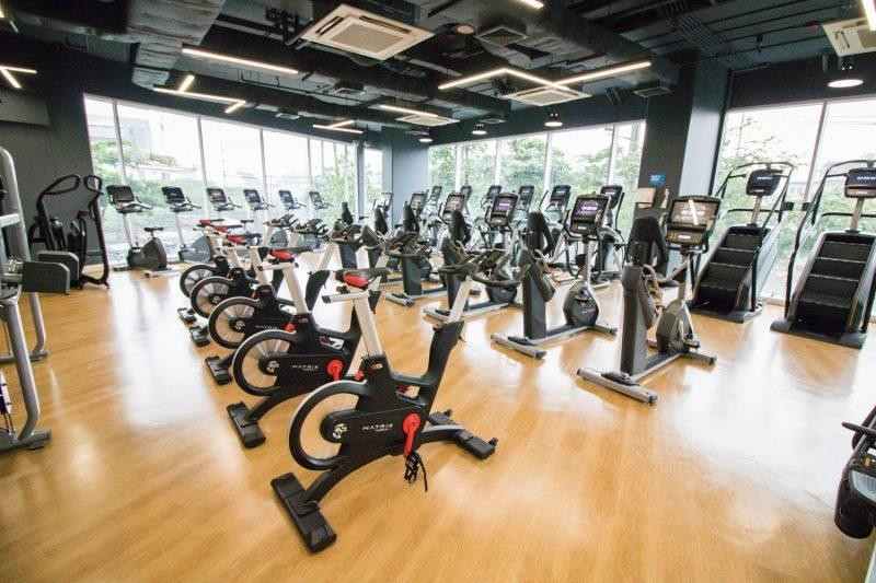 Person using a stationary gym bicycle for weight loss in a modern USA gym.