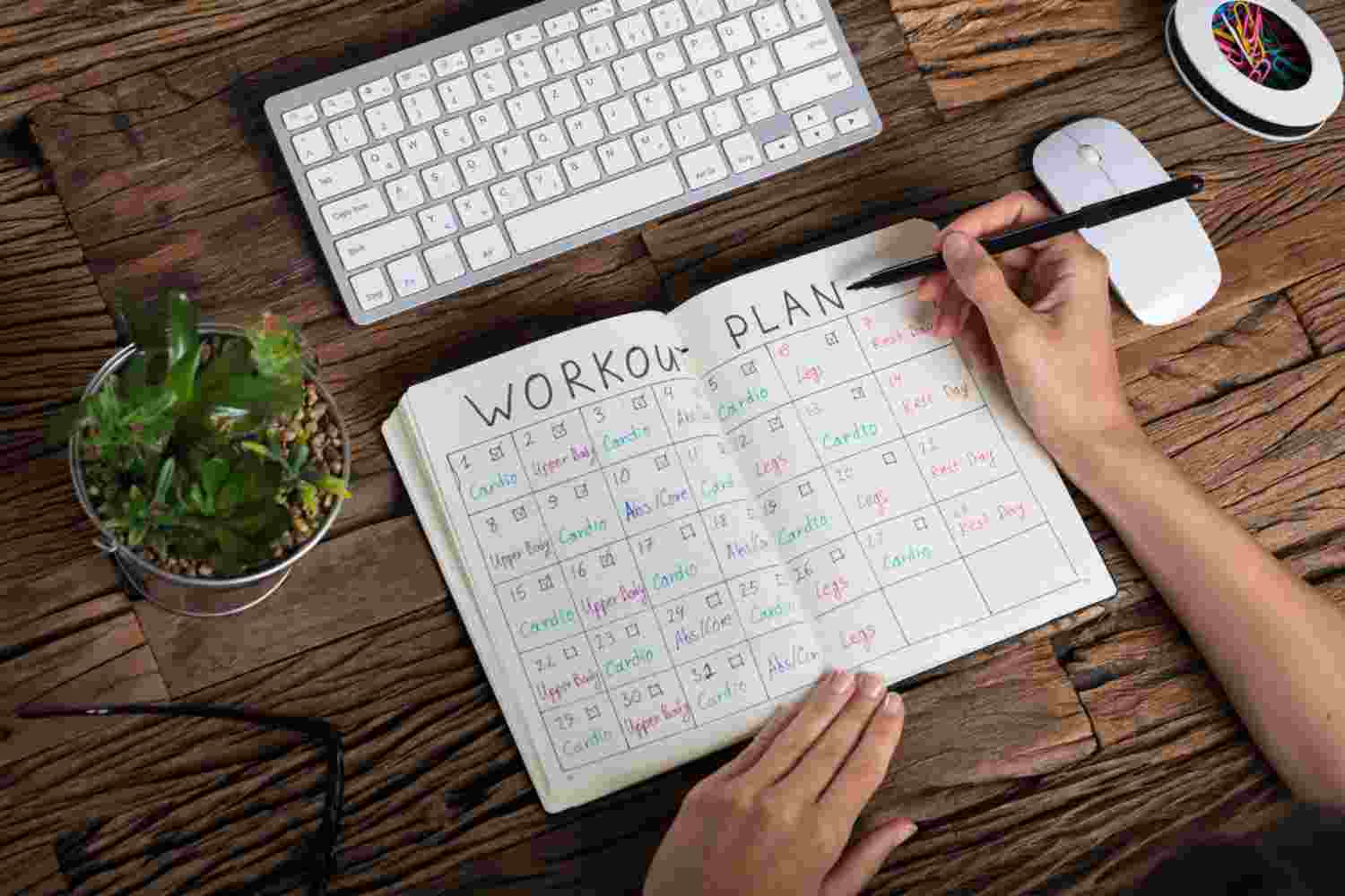 Weekly exercise bike workout schedule with fitness planning notebook.
